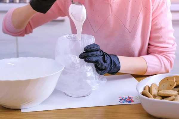 Женские руки кладут сахар сладкая глазурь в сумку для украшения печенья и пряничных домиков . — стоковое фото