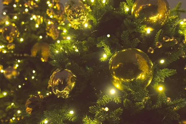 圣诞金球和花环与球茎在圣诞树的分支, 特写视图. — 图库照片