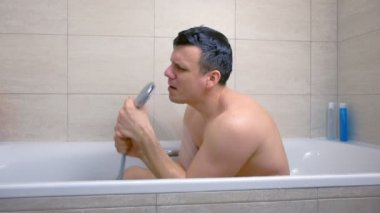 Mutlu adam küvette yıkanırken şarkı söylüyor..