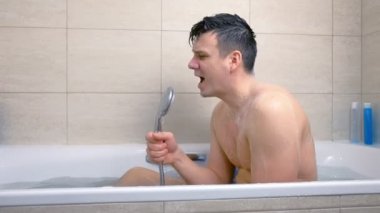 Adam küvette yıkanırken coşkuyla şarkı söylüyor..