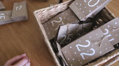 Kadın hasır sepete noel gelişi takvim çanta koyar. Yakın eller.