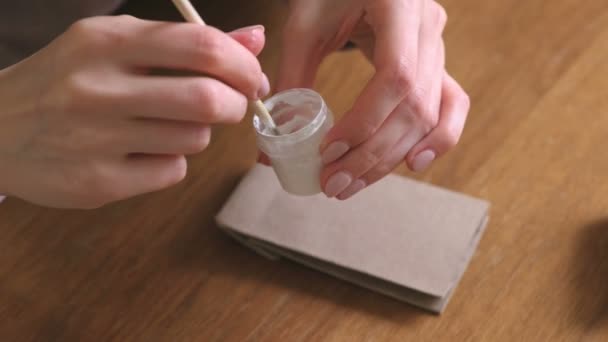 Kvinner lager julekalender for barn. Skriver et nummer på posen med pensel og hvit maling. Lukk hendene. . – stockvideo