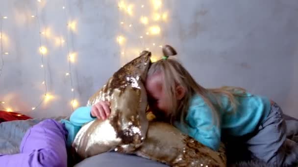 Two girls sisters jumping playing on bed in Christmas interior with garlands. — Stock Video