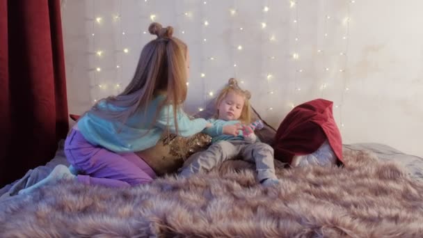 Duas meninas irmãs brincando esconder e procurar cobrir os olhos por mãos na cama . — Vídeo de Stock