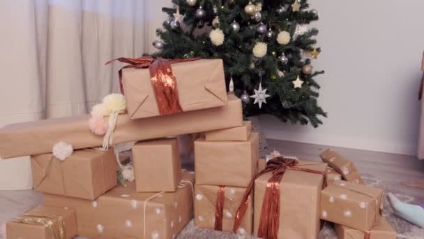 Schwestern bauen Turm aus Geschenkboxen in der Nähe des Weihnachtsbaums. — Stockvideo