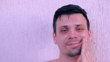 Genç adam taze ev yapımı hindistan cevizi maskesi ve yüzüne scrub uyguluyor.