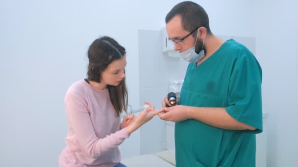 Chirurg untersucht Warze am Finger mit Dermatoskop-Lupe vor Entfernung. — Stockvideo