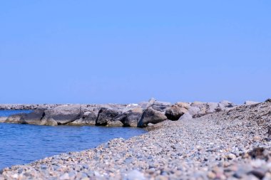 Berrak gökyüzü ile güneşli bir günde Deniz taş plaj.