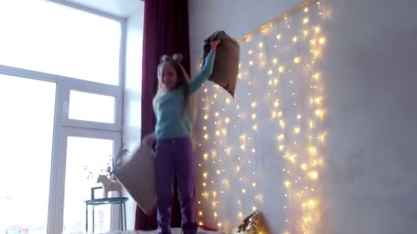 Feliz chica adolescente jugando saltar en la cama en el interior de Navidad con grandes ventanas . — Vídeos de Stock