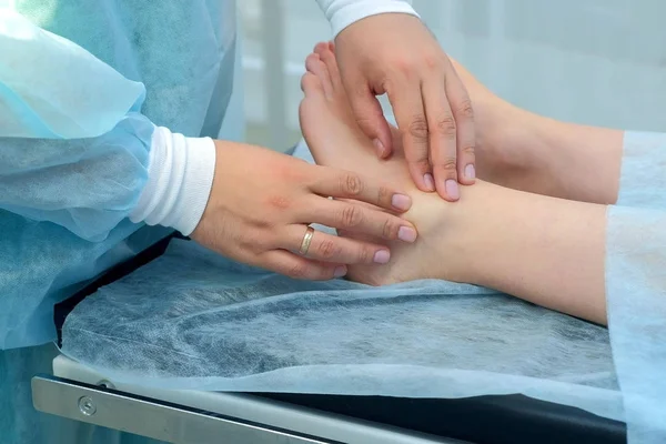 Cerrah eklem, closeup ayak bileği hygroma kaldırmak için ameliyat öncesi bacak palpates.