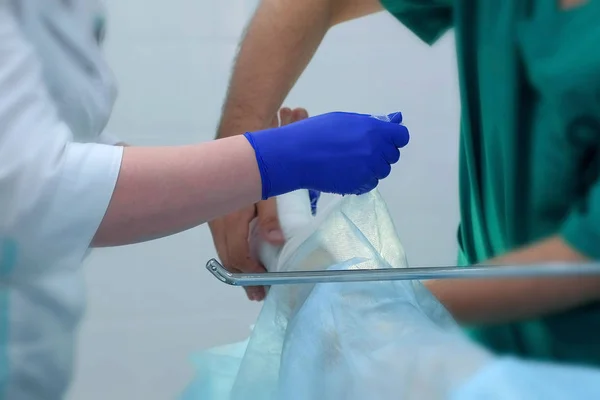 Nurse and doctor surgeon bandage patients leg foot after surgery, closeup view. — Stock Photo, Image