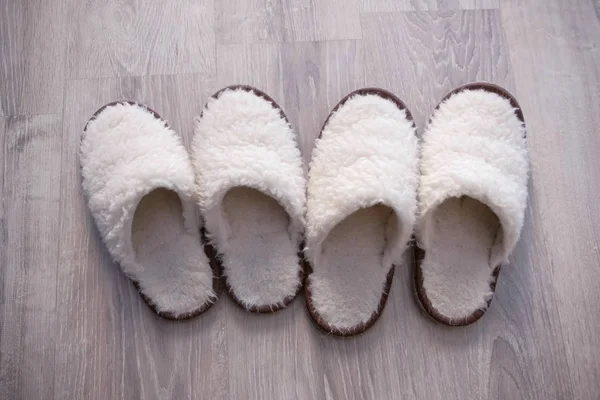 Two pairs of white slippers from sheep wool, closeup view. — Stock Photo, Image