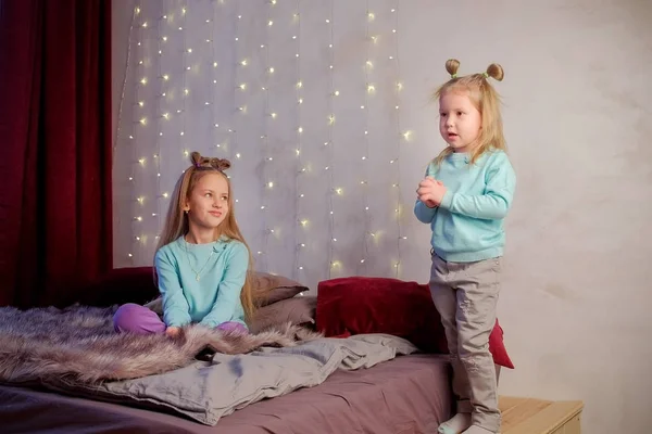 Kleines süßes Mädchen mit ihrer Schwester erzählt das Gedicht im Schlafzimmer zu Hause, Kinder. — Stockfoto