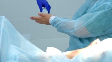 Cerrah, hastanedeki ameliyathanede ameliyat öncesi el antiseptiğini tedavi eder..