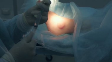 Cerrah ameliyattan önce lokal anestezi için şırınga ilacı yazıyor..
