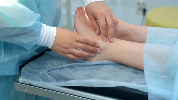 Surgeon palpates leg before surgery to remove ankle hygroma in joint, closeup. — Stock Video