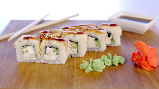 Strooi rolt met sesamzaad geserveerd in houten plank met wasabi, gember en soja saus. — Stockvideo