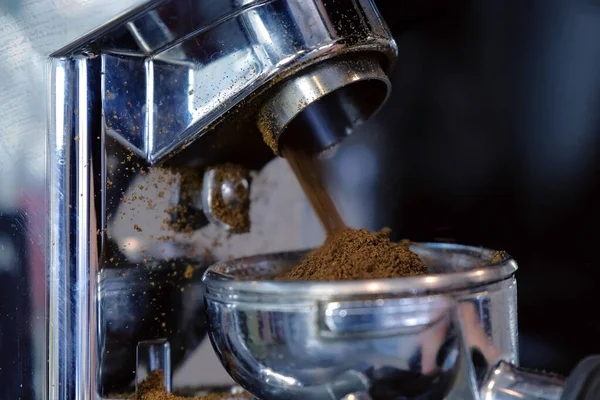 Mielenie ziaren kawy przy użyciu szlifierki do kawy i uchwytu. — Zdjęcie stockowe