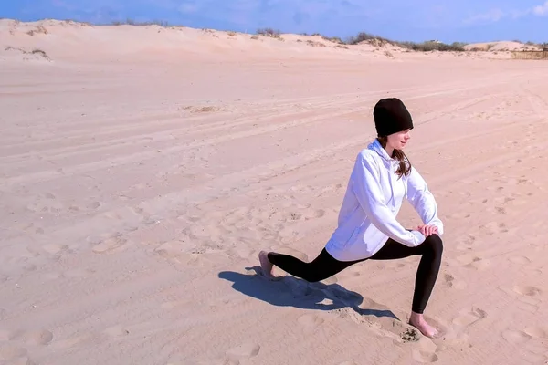 Девушка делает высокий ланч поза на пляже песчаный йога тренировки на открытом воздухе . — стоковое фото