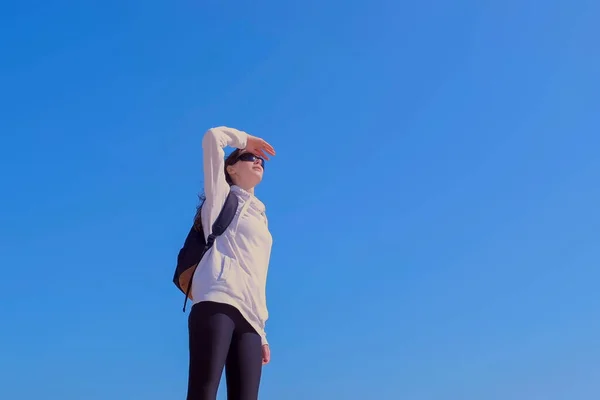 Femme touriste regarde sur les côtés sur fond de ciel bleu randonnée en plein air en vacances . — Photo