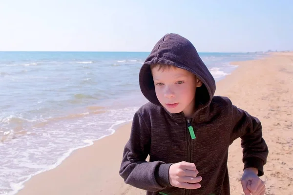 Niño niño está corriendo caminando en la playa de arena de mar pequeño corredor en el deporte al aire libre . — Foto de Stock