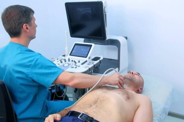 Hasta tiroit bezini ultrason tarayıcı kullanarak muayene eden doktor..