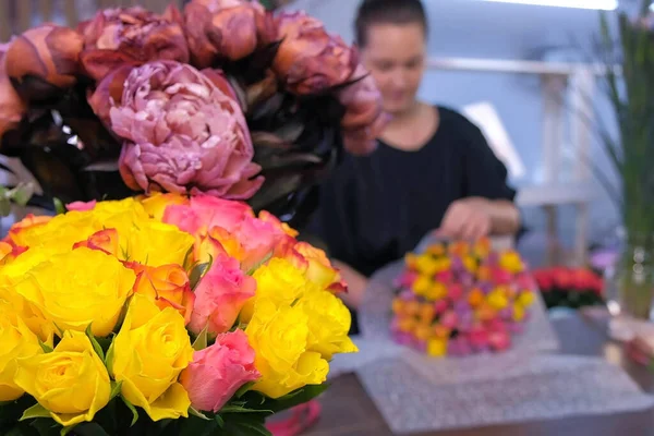 Fundo Borrão com florista embalagem rosas boquete na loja de flores . — Fotografia de Stock