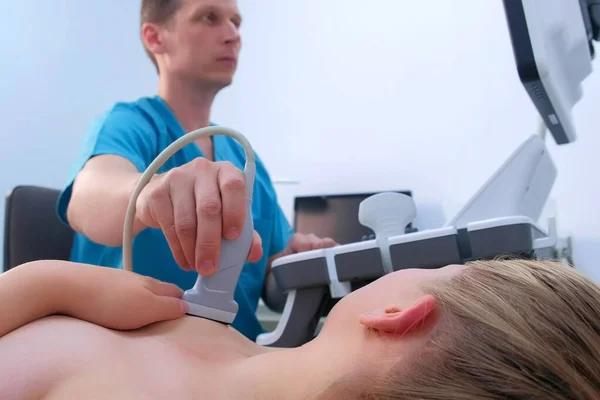 Muž lékař dělat ultrazvukové diagnostiky mléčné žlázy mladé ženy. — Stock fotografie