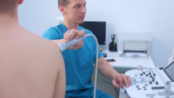 Ultraschalluntersuchung für Mann am Schultergelenk am Arm in Klinik. — Stockvideo