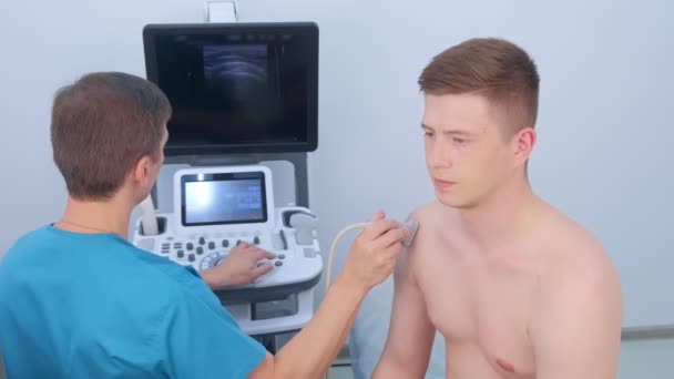 Badanie ultrasonograficzne dla faceta na stawie barkowym w klinice. — Wideo stockowe