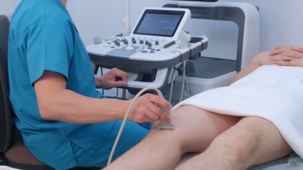 Ultrasound screening of knee joint for man using ultrasound scanner in clinic. — Stock Video