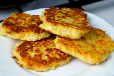 Kızarmış patatesli krep, mutfakta tabakta draniki. Taze yemek hazırlanıyor. Mutfak, mutfak, yemek tarifi. Geleneksel Rus yemekleri öğle yemeğinde sebze yağında kızartılıyor..