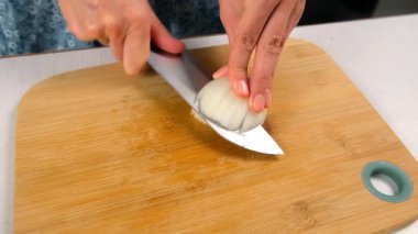 Aşçı kadın ustalıkla mutfakta beyaz soğan doğruyor. Taze malzemeler, mutfak teknikleri, ev yapımı sağlıklı sebzeler, yemek pişirme, keskin baharatlar..