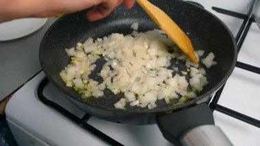 Aşçı kadın mutfakta haşlanmış soğan ve sarımsak pişiriyor. Mutfak teknikleri, ev yapımı sağlıklı yemek hazırlama, yemek yemeği, mutfak, yemek için baharat iyi tat..