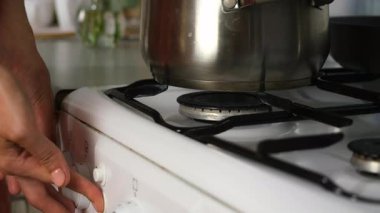 Mutfakta yemek pişirmek için fırını açan kadın tencerede yemek pişiriyor, elleri yakın plan. Mutfak, aşçılık, yemek, ev yemeği, yemek tarifi, taze organik malzemeler konsepti..