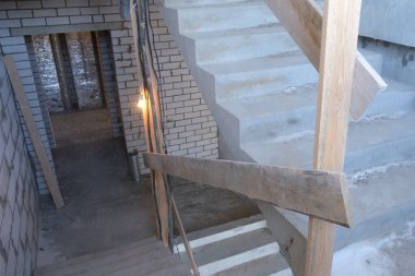 Tuğladan duvarları olan çok katlı bir binanın merdiveni. Kendi kendini bitiren biri için zor onarımlar. Çimento iç dekorasyonu, çıplak oda duvarları, inşaat sahnesi..