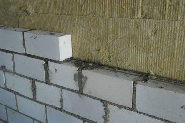 İnşaat, tuğla döşeyerek bina duvarları oluşturmaya çalışıyor. Zorlu bir bitirme çalışması. Apartman dairesinde malzemeler olan bir inşaat alanı. Duvarların içeriden güçlendirilmesi.