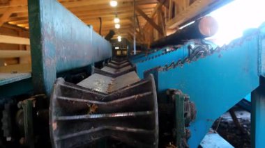 Ahşap fabrikasındaki kereste kütüğü için metal taşıyıcı. Kereste işleme ve marangozluk endüstrisi. Atölyedeki kereste fabrikasında tahta testeresi kesme işlemi..