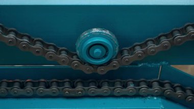 Endüstriyel fabrikada hareket eden yakın çekimli metal zincir taşıyıcı şerit. Modern fabrikada endüstriyel ekipmanların otomatik mekanizması. Ahşap işçiliği, metal endüstrisi imalatı.