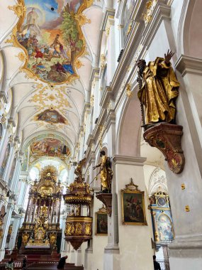 In the Peterskirche, one involuntarily wants to raise one's head and not take one's eyes off the picturesque beauty of the religious ceiling painting.
