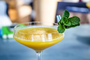 Sarı mango nane yaprağı bir cam ile kokteyl.