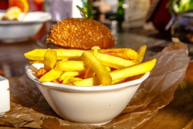 Burger peynir, domates, salatalık, soğan ve patates kızartması ile gemide olduğunu.