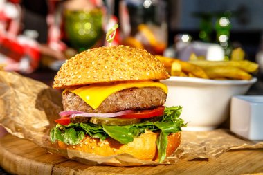 Burger peynir, domates, salatalık, soğan ve patates kızartması ile gemide olduğunu.