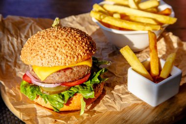 Burger peynir, domates, salatalık, soğan ve patates kızartması ile gemide olduğunu.