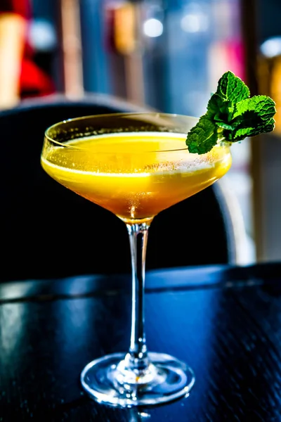 Sarı mango nane yaprağı bir cam ile kokteyl.