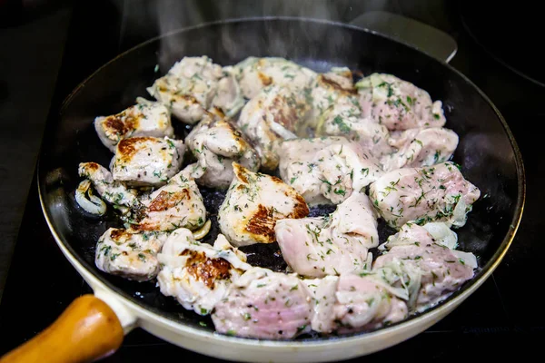 Otlar bir tavada kızartılmış sığır eti parçaları.