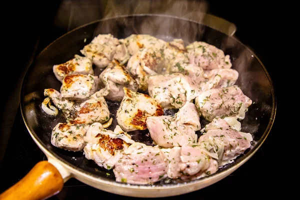Otlar bir tavada kızartılmış sığır eti parçaları.