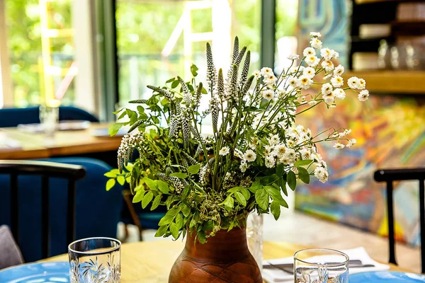 Beyaz kır çiçekleri toplanan alanında bir buket bir suyudur