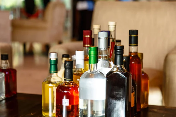 アルコール飲料の多くの種類のボトルがテーブルに — ストック写真