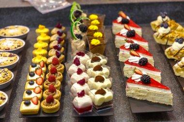 Birçok farklı küçük kek şeker dükkanı camda vardır.